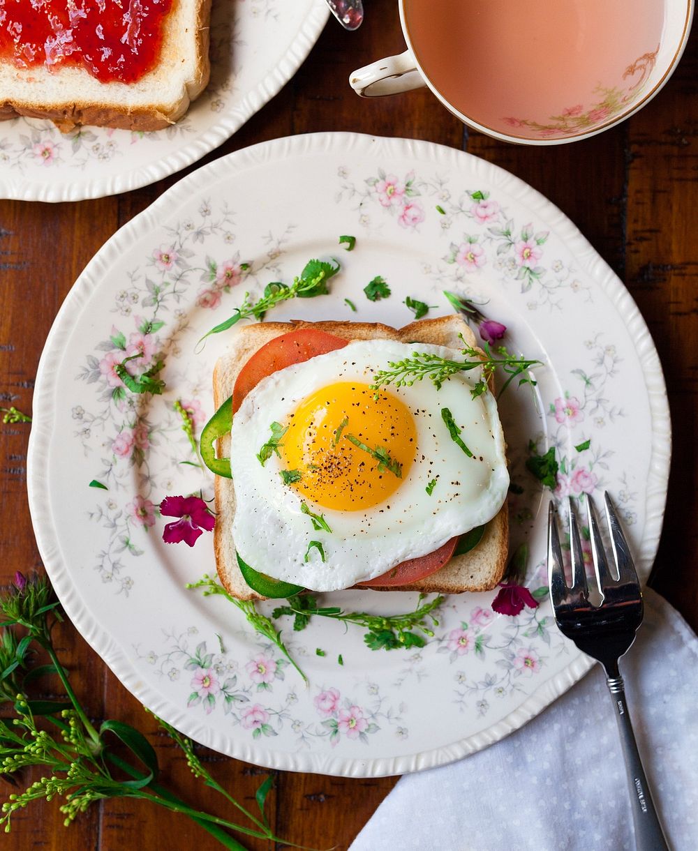 Breakfast toast with fried egg, tomato, and herbs. Original public domain image from Wikimedia Commons