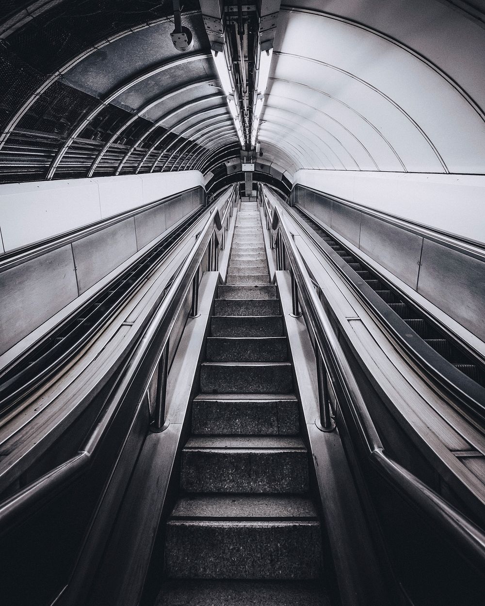 An empty staircase and two escalators in a tunnel in London. Original public domain image from Wikimedia Commons