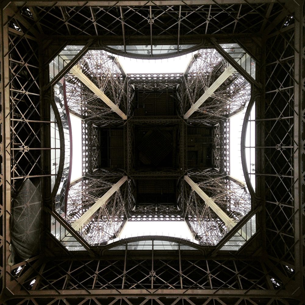 Street view looking inside the architecture of the Eiffel Tower in Paris, France.. Original public domain image from…