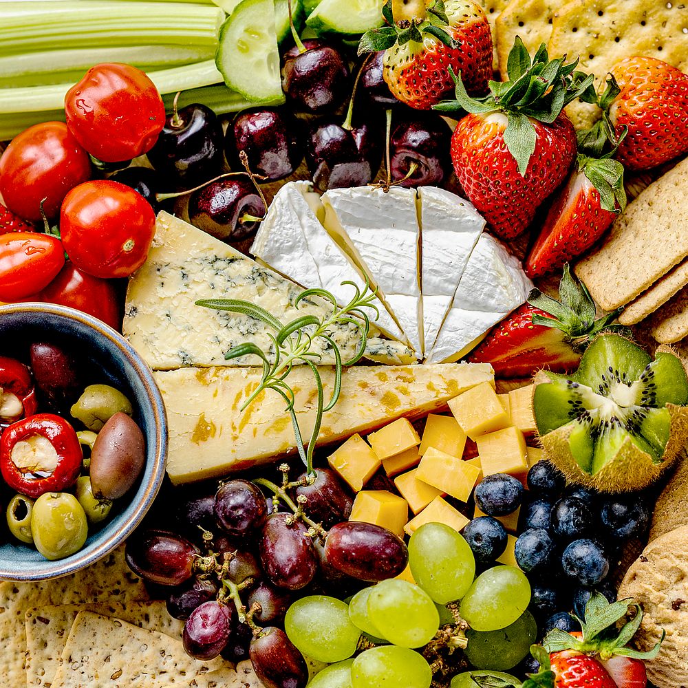 Snack board with cheese, fruits and crackers