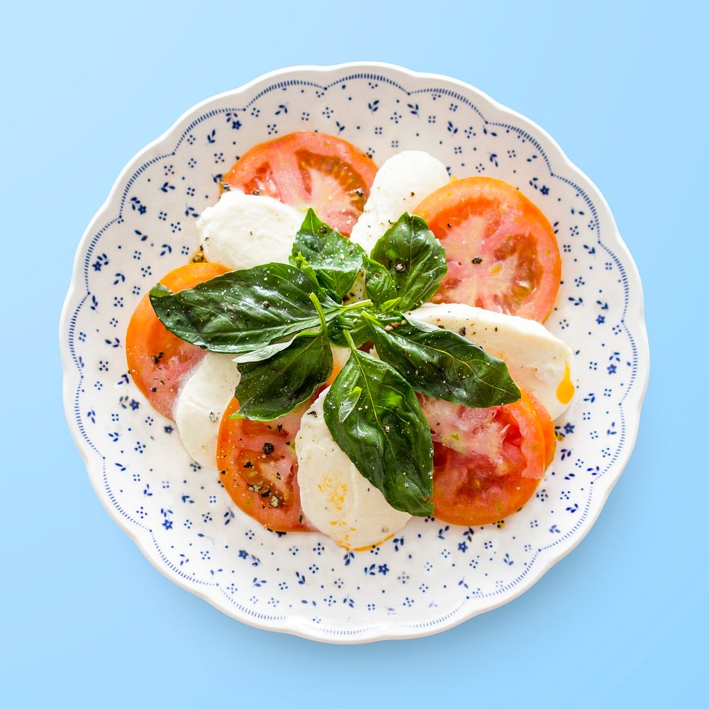 Caprese salad on a plate, Italian cuisine on blue background, food photography