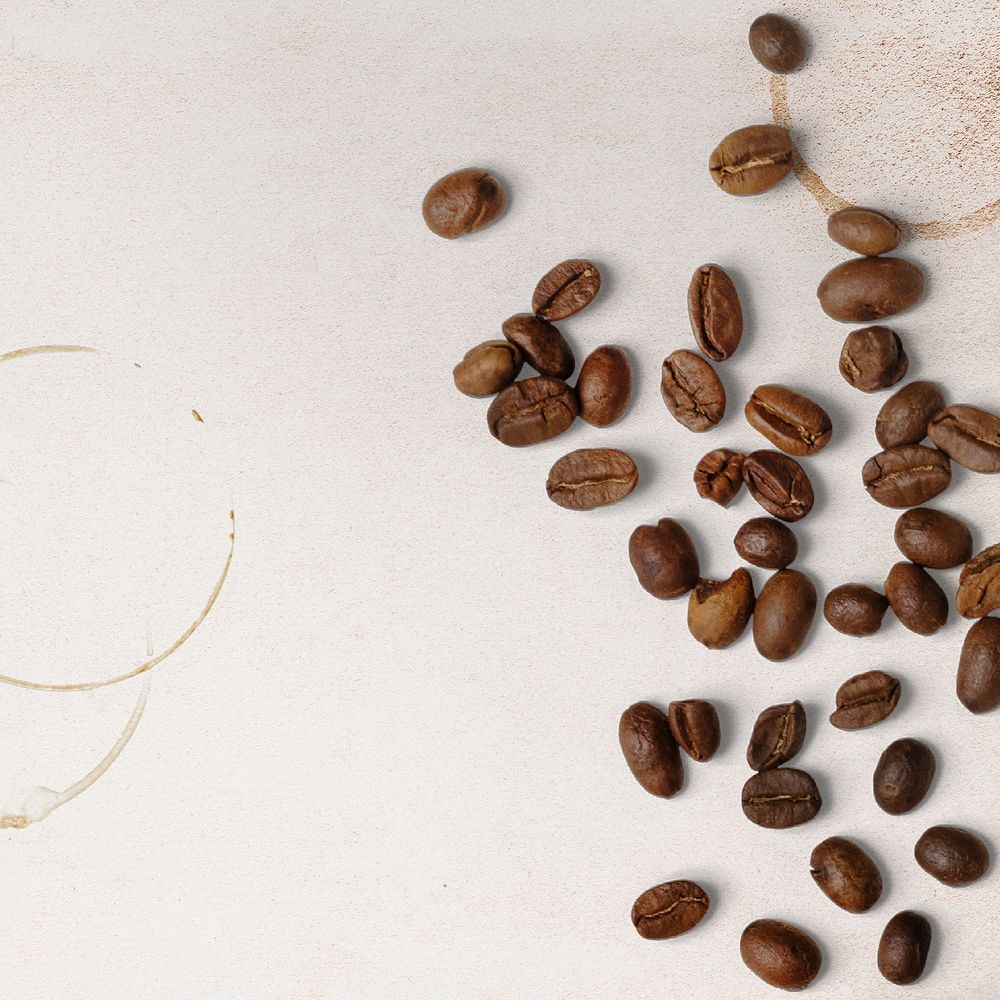 Beige background, coffee beans and brown stain