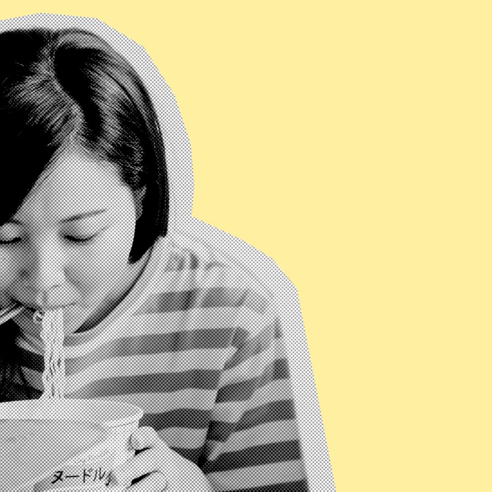 Asian woman eating instant noodles during coronavirus quarantine