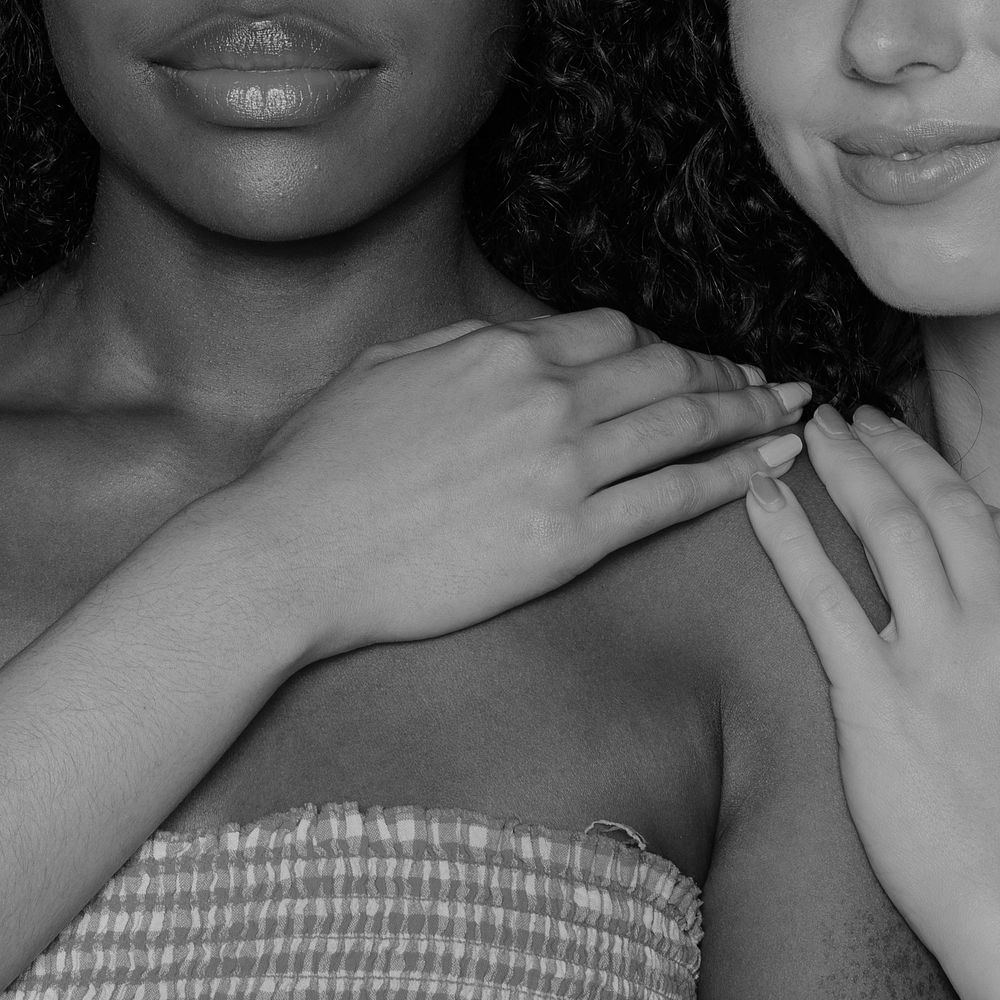 Two diverse women holding each other black and white closeup