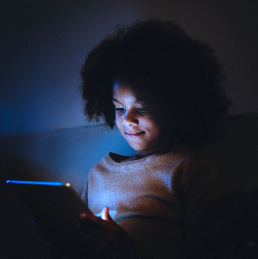 Little girl using tablet at night