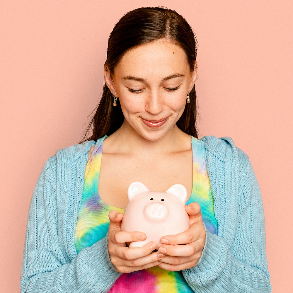 Beautiful woman holding piggy bank for financial savings campaign